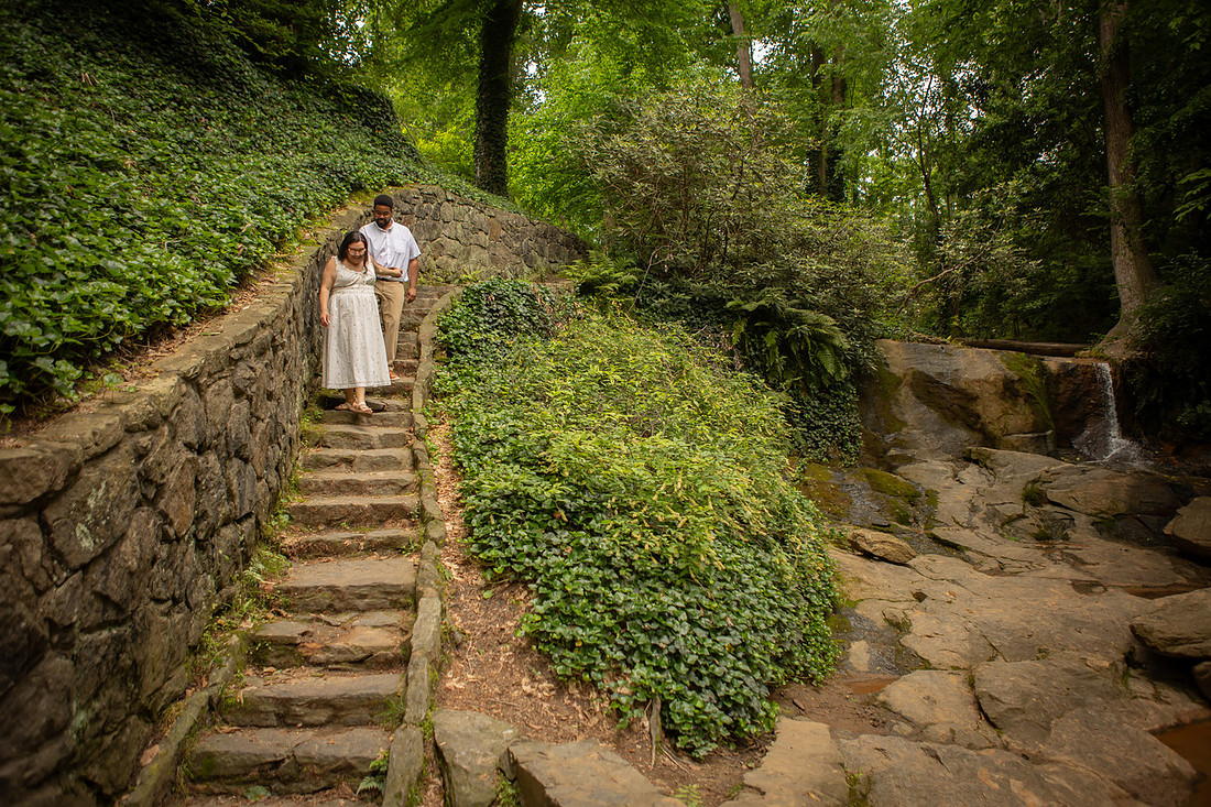 Couple Walking Down Stairs Next TO Ivy and Waterfall
