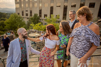 family looking at one guy after a surprise proposal behind the grove park inn on the sunset terrace