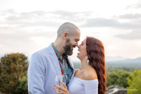 couple touching noses and laughing while holding a glass of champagne
