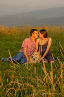 boyfriend and girlfriend cuddling with their dog at max patch during sunset