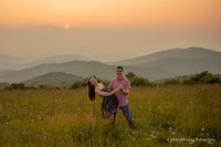 couple dancing in a field during sunset in the mountains