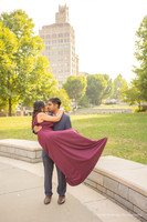 man holding a woman in a red dress and kissing her in downtown Asheville