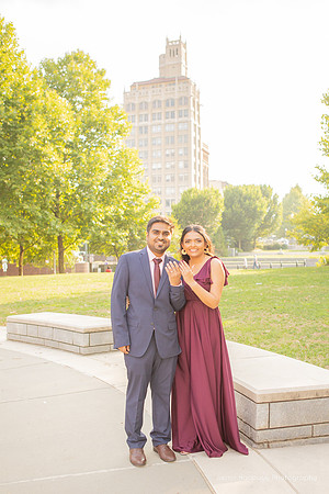 man and woman both holding up their engagement rings n downtown Asheville