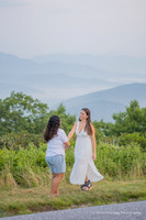 two women both wearing white dancing in the mountains