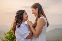 lesbian couple leaning their foreheads together with a mountain view backdrop