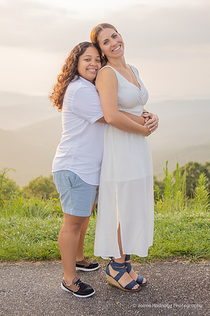 Two women wearing white hugging on the Blue Ridge Parkway