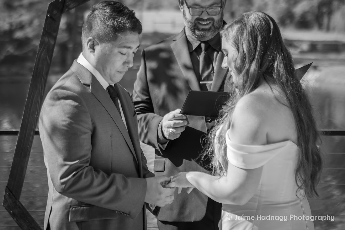 Black and White photo of groom putting ring on bride's finger | NC Wedding Photographer